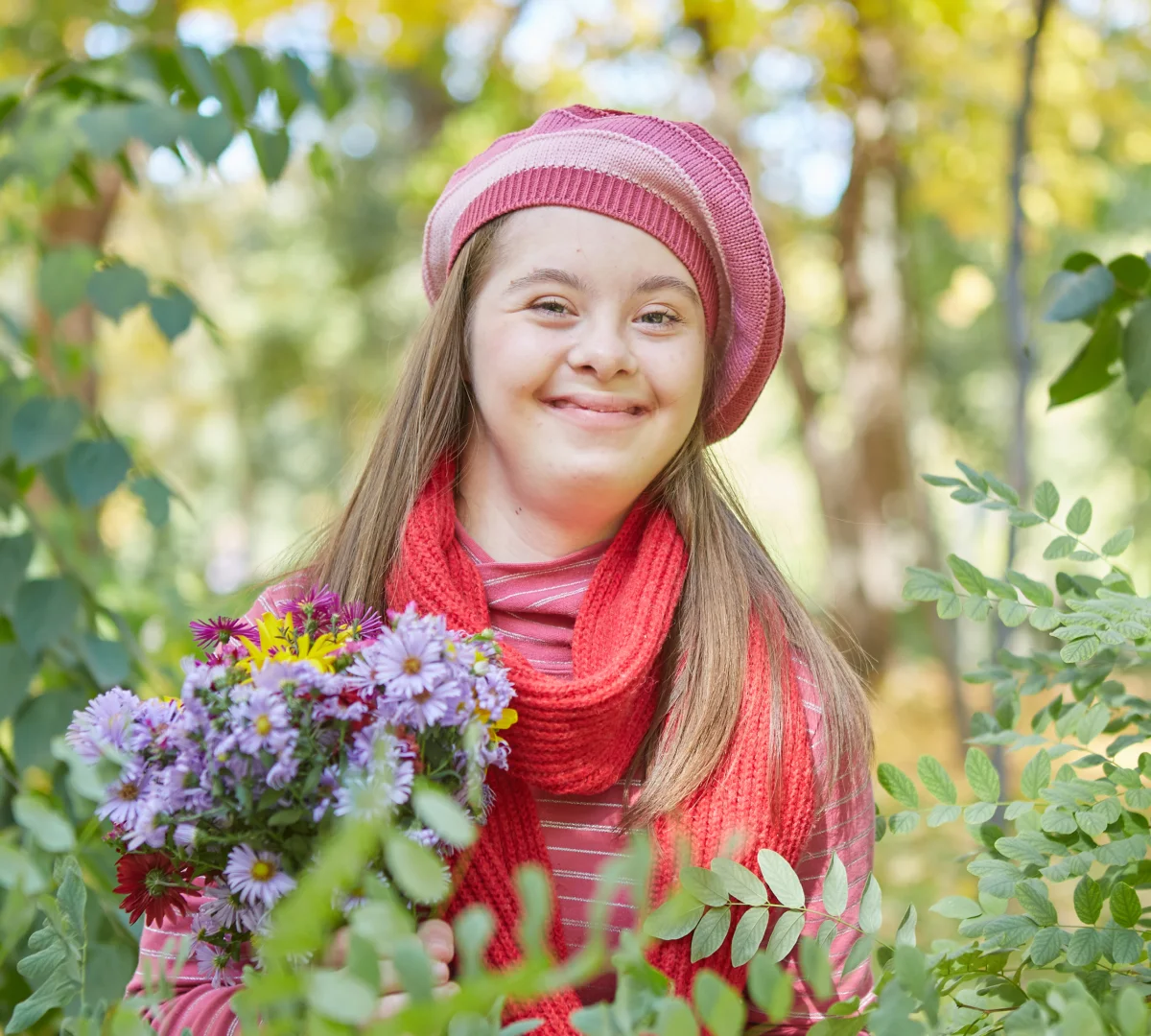 A young woman with Downs syndrome holding a bunch of flowers